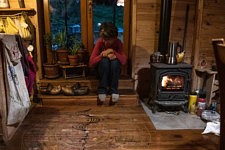 Valerie contemple le mandala peint à même le sol, tout juste terminé, par une amie paysanne en remerciements de leur aide dans son propre projet de ferme ecologique, 23 novembre 2022. (c) Céline Gaille / Hans Lucas pour le Forum Vies Mobiles. 