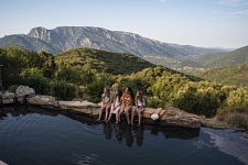 Des enfants se rafraichissent dans une piscine d'eau de source, face au massif du Caroux, Mons La Trivalle, 20 juillet 2024. 